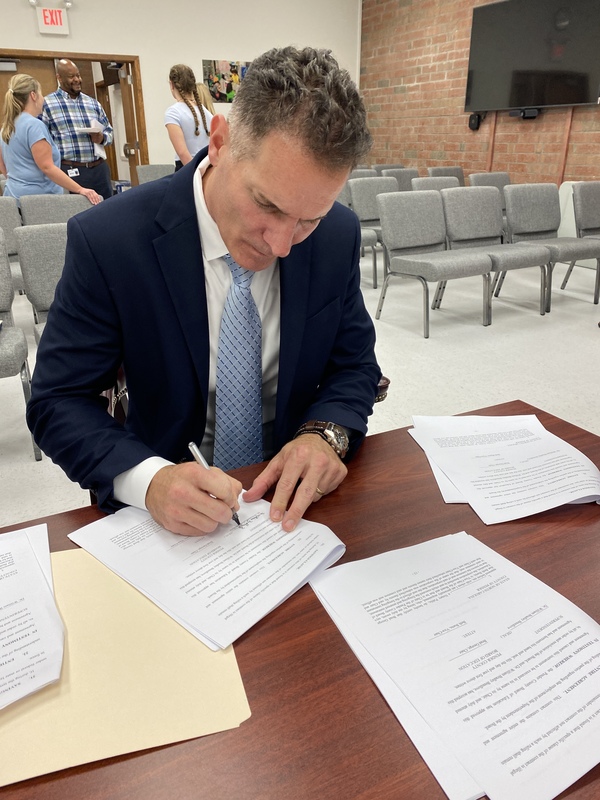 Dr. Breedlove signs his contract which runs through 2026.